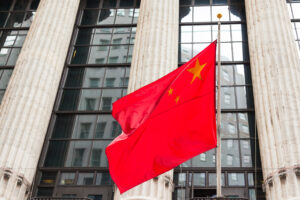 Chinese flag floating in front of a goverment building