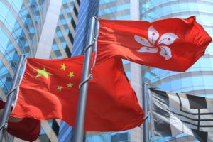 hong kong regional flag and China flag in the wind with building